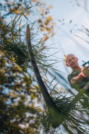 Male farmer mows the grass with an old scythe