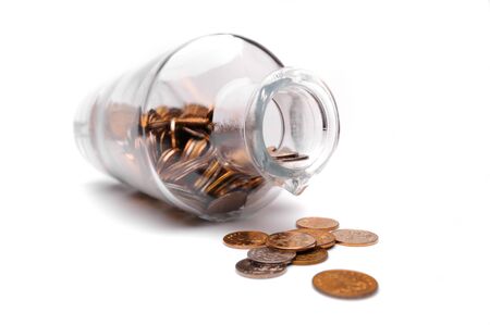 Glass bottle full of coins on a white backgroundの写真素材