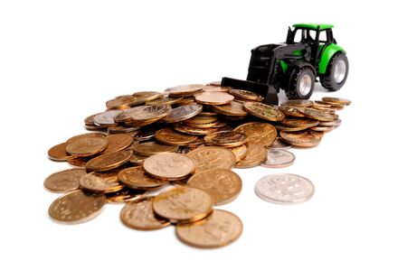 Green tractor raking up coins, white backgroundの写真素材