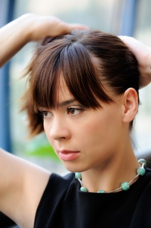 Attractive young woman arranging her hairの写真素材
