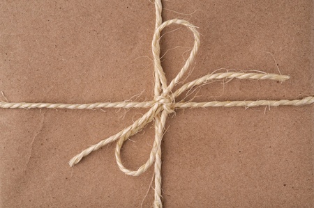 String tied in a bow, on a brown recycled paper packageの写真素材