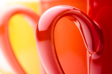 Perspective row of bright colorful mugs, red, orange, yellow and white, on a white backgroundの写真素材