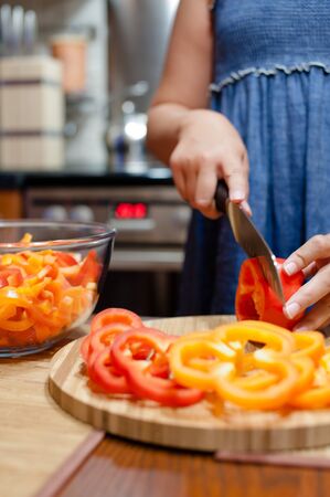Woman cutting sweet peppersの写真素材