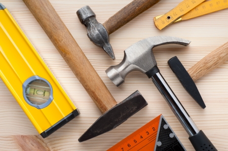 Assorted construction and measurement tools arranged on a wooden surface. Construction, repair or home improvement background.の写真素材