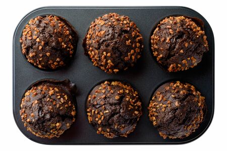 Food: dark chocolate muffins with roasted peanuts in baking pan, isolated on white backgroundの写真素材