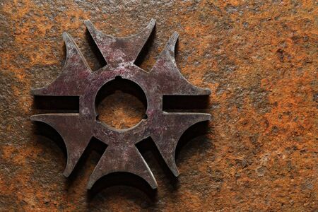Backgrounds and textures: rusty steel six-pointed star or cross, on heavily corroded metal surfaceの写真素材