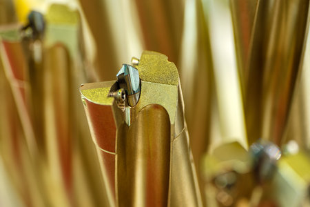 Metalworking tool twist drill, close-up shot with beautiful golden blurred background, industrial...