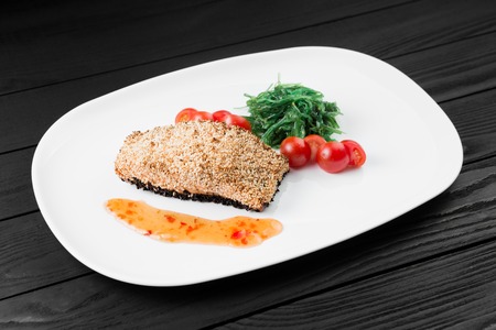 Grilled salmon with potatoes and sauce on white plate.の写真素材