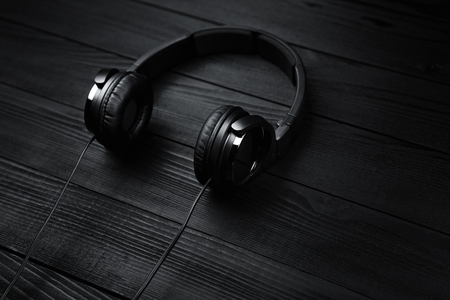 Black headphones on black wooden dark background.の写真素材