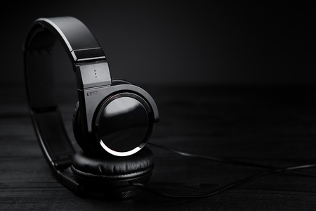 Black headphones on black wooden dark background.の写真素材