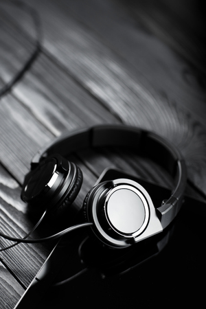 Digital tablet and headphones on a dark wooden table.の写真素材
