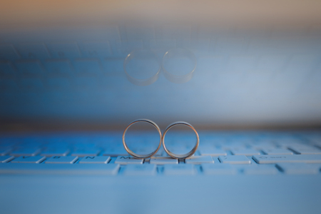 Wedding rings on the keyboard of notebook computer. Love concept. Text space.の写真素材