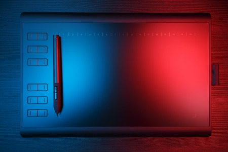 Graphic tablet with pen for illustrators and designers on black wooden background.の写真素材