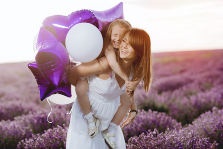 Mom and Daughter in the lavender field. Family love concept.の写真素材