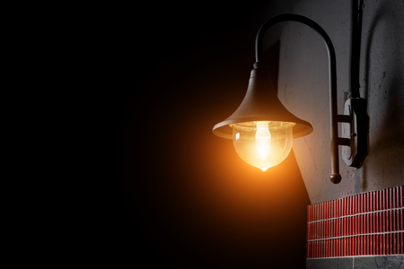 Photo of vintage lamp on the wall in dark night. Street light. Copy space.の写真素材