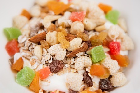 A bowl of healthy breakfast muesli with yogurt and nuts.の写真素材