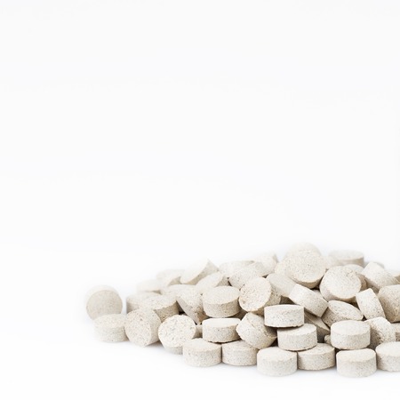 Herbal pills or capsules on whie background with copy space. Drug prescription for treatment medication. Pharmaceutical medicament, cure in container for health.の写真素材