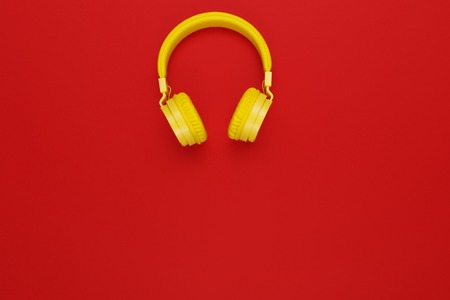 Yellow headphones on red background. Music concept.の写真素材