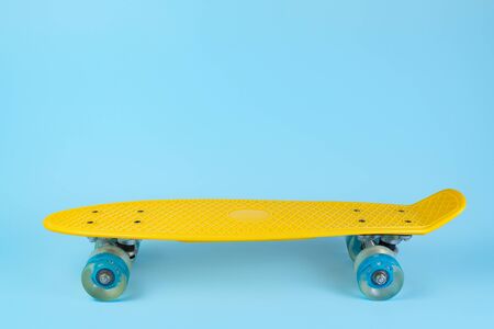 Photo yellow skateboard or pennyboard on blue background. Copy space.の写真素材