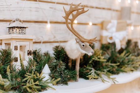 Christmas festive decoration with candles, garlands, fir tree and realistic toy deer.の写真素材