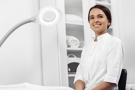 Portrait of a young female professional cosmetologist in cosmetology cabinet.の写真素材