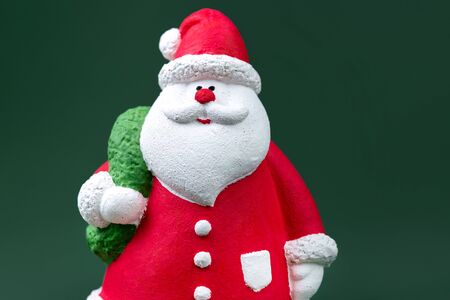 Close-up photo of gypsum colorful santa claus isolated over green background. New Year and Christmas concept.の写真素材