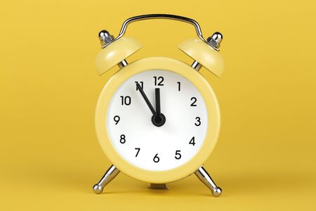 Yellow round alarm clock on the yellow background.の写真素材