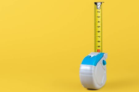 Measuring tape isolated over yellow bakground. Carpenter and Construct concept.の写真素材