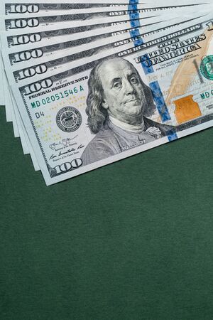 Stack of one hundred american dollars bills over green background.の写真素材