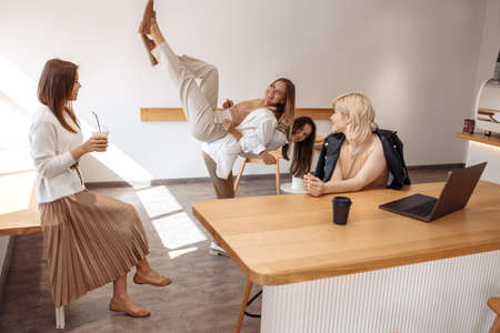 Funny four young women friends having fun at the cafe indoors.の写真素材