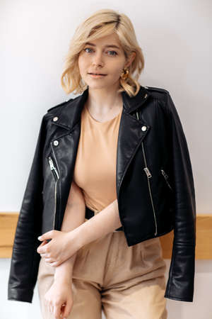 Pretty young blonde woman posing at the cafe indoors.