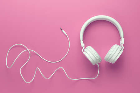 Modern white headphone on pink background. Music concept.の写真素材