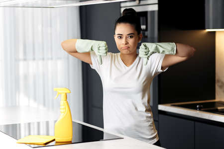 Unhappy female showing bad gesture in the kitchen.の写真素材