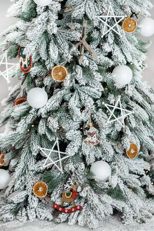 Close-up image of Christmas festive decoration with garlands, reindeer toy, white balls, angels, stars and dried orange.の写真素材