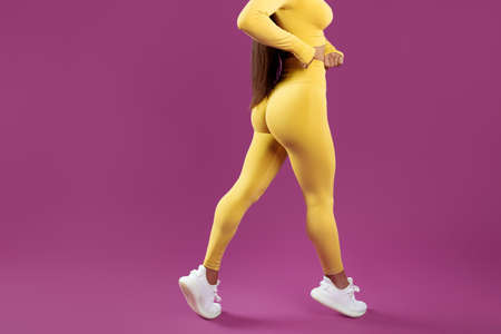 Close-up image of young brunette woman over purple background. Perfect body.の写真素材