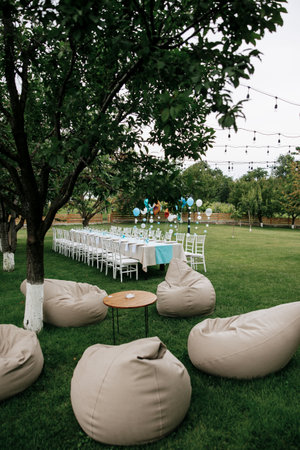 Photo of festive table in summer outdoor. Cozy vibe.