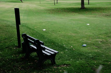A bench and sign at a tee on a golf courseの写真素材