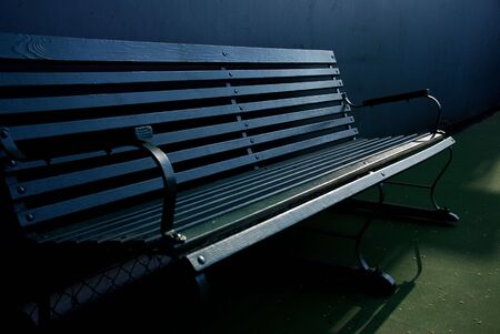 Classic dark green bench on a tennis courtの写真素材