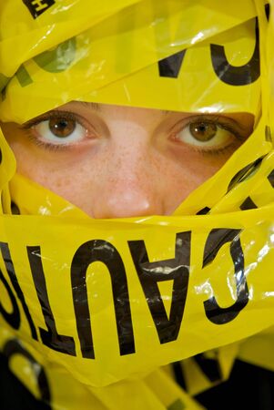 Face of teenage girl wrapped in caution tape