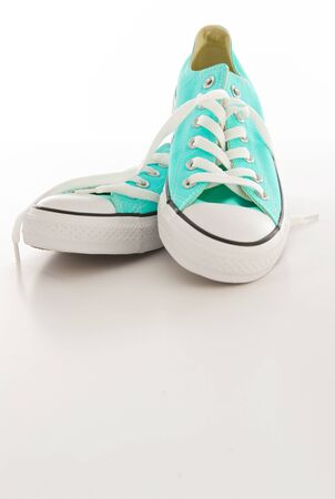 Pair of turquoise and white sneakers with laces on a blank backgroundの写真素材