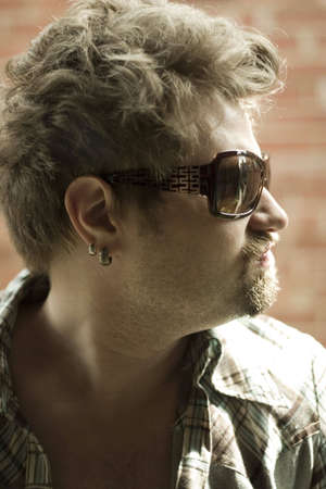 portrait of the guy on the grunge brick wall background
