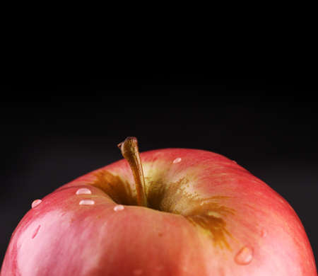Apple with waterdrops over black background