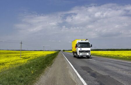 Truck riding among the rape fieldsの写真素材