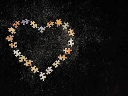 Background texture: heart shape on puzzle paper background. Puzzle in the details in the form of a mosaic. Concept: love, relationships, unity, heart feelings.の写真素材
