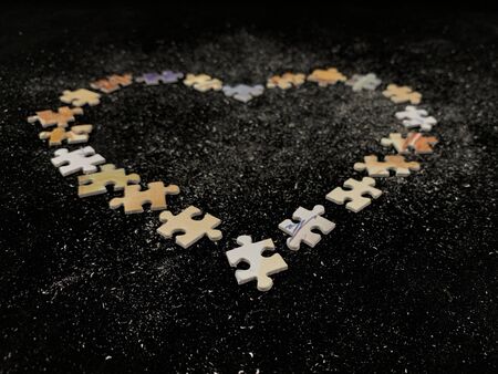 Background texture: heart shape on puzzle paper background. Puzzle in the details in the form of a...