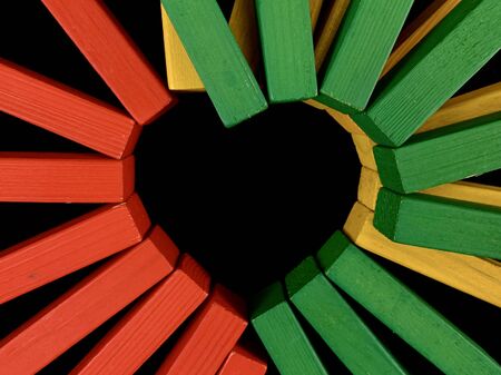 Multi-colored sticks in the shape of a heart on a black background. Heart made of colorful wooden planks. Concept: valentines day, love, relationship, feelingsの写真素材