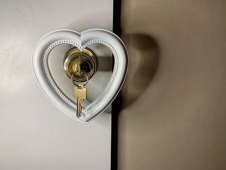 Heart on a doorknob with a key. The white heart opens with keys. Concept: closed heart, open soul.の写真素材