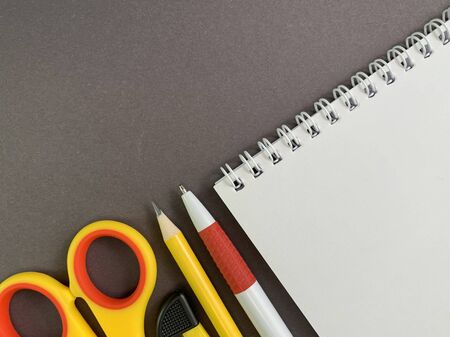 Background texture: school stationery on the desk, yellow and orange. Stationery for the office, free space for writing. Concept: back to school, scissors and paper, office supplies.の写真素材