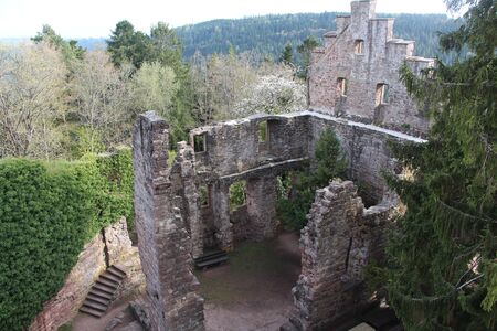 The ruins of an old castle on top of a mountain. The ruins of a medieval fortress in a forest among nature. Historic site, destroyed walls, Germany, April 2016.のeditorial素材