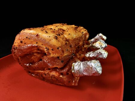 A large piece of fried meat, on a black background. Spicy meat ribs for cooking on fire. Marinated pork and veal for baking in the oven.の写真素材